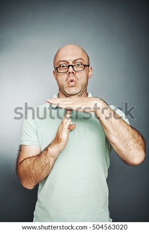 man showing time out hand gesture, frustrated screaming to stop. on gray background. Human emotions face expression reaction