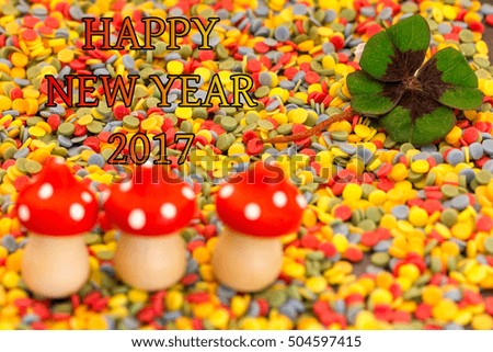 Three flying mushrooms and a clover leaf on colorful confetti for New Year 2017