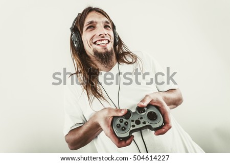Playing games. Young smiling cheerful man play on console xbox playstation. Guy with pad joystick. Royalty-Free Stock Photo #504614227