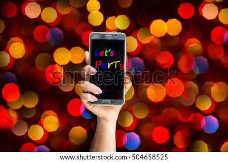 Women hand shows smartphone in vertical position on abstract bokeh background, technology- Let's party message
