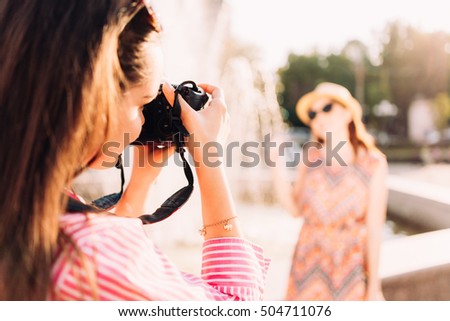 girls taking pictures on film camera outdoor in the city