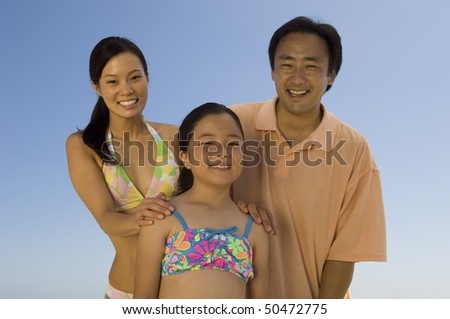 Parents with daughter (7-9), outdoors, (portrait)