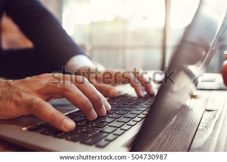 Work with opened laptop and pc using. Close-up photo of male hands typing on keyboard. Business, technologies, communication concept