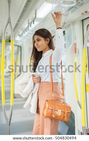 Beautiful Asian businesswoman using smartphone in the LRT Train 