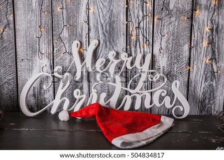 Merry Christmas and Happy Holidays!  Christmas tree, Santa hat and the words on old dark wooden rustic background