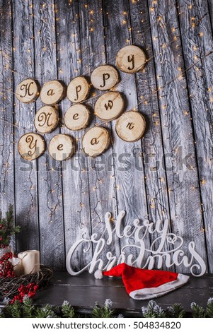 Merry Christmas and Happy Holidays!  Santa hat and the words on old dark wooden rustic background