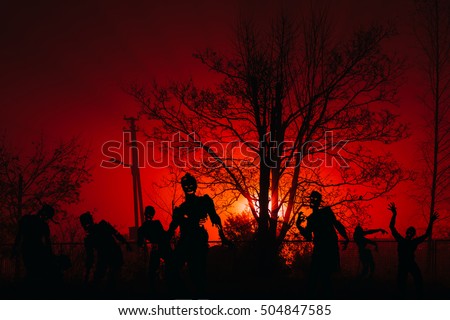 crowd of hungry zombies in the woods. Silhouettes of scary zombies walking in the forest at night Royalty-Free Stock Photo #504847585