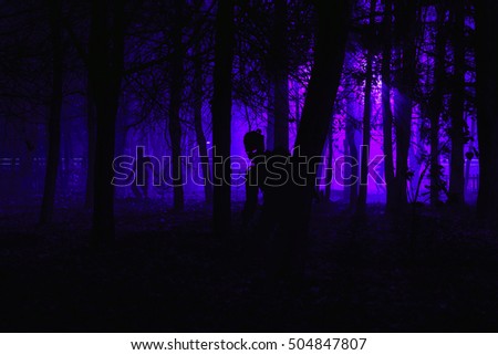 crowd of hungry zombies in the woods. Silhouettes of scary zombies walking in the forest at night