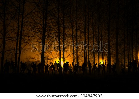 crowd of hungry zombies in the woods. Silhouettes of scary zombies walking in the forest at night. yellow Acid variant Royalty-Free Stock Photo #504847903
