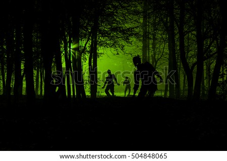 bloodthirsty zombies attacking. hungry zombies in the woods. Silhouettes of scary zombies walking in the forest at night Royalty-Free Stock Photo #504848065