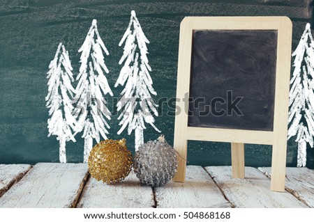 christmas decorations next to empty blackboard for copy space