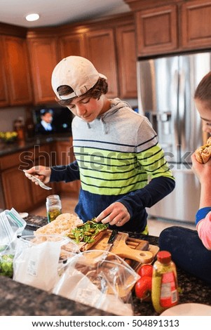 Brother and sister in kitchen preparing sandwich