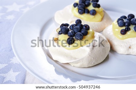 meringue nests topped with lemon curd and blueberry