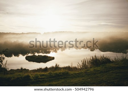 Small lake in the foggy weather