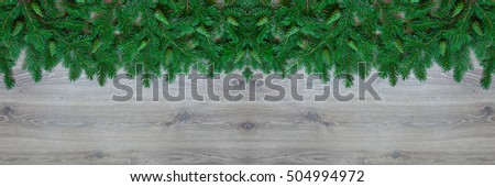Christmas border - branches of pine with cones isolated on natural wooden background, horizontal banner.
