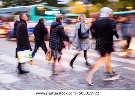 picture in motion blur of people crossing a city street at night