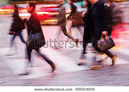 picture in motion blur of people crossing a city street at night