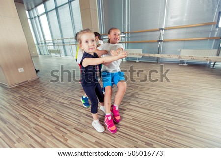 Group of kids pulling a rope in fitness room