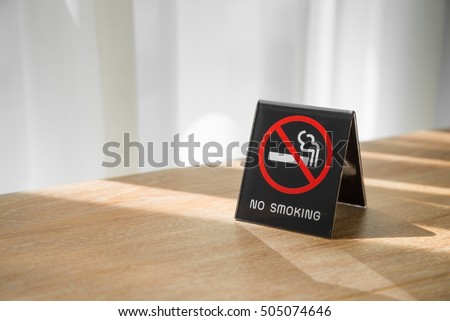 No smoking sign on wooden table in hotel room