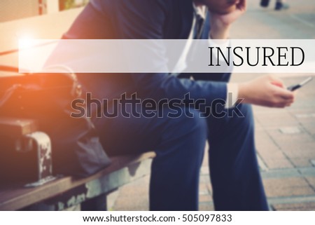Hand writing INSURED with the abstract bokeh on background. This word represent the business as concept in stock photo.