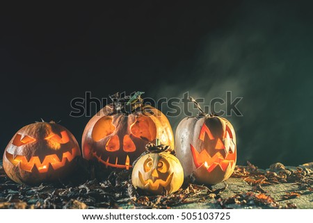 Halloween pumpkins at wood background. Carved scary faces of pumpkin.
