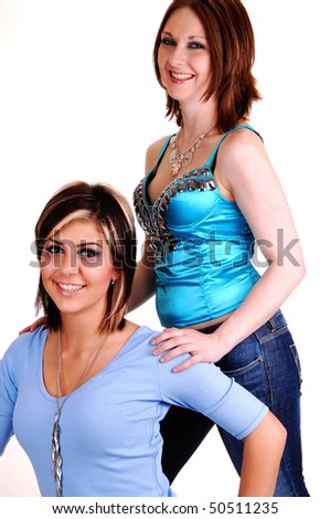Two woman friends, one standing and the other sitting in a portrait shot, smiling and being happy, for white background.