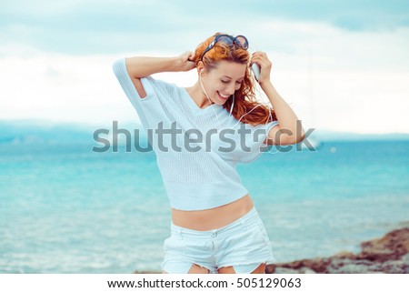 happy woman enjoying nature dancing listening to the music outdoors sea background  