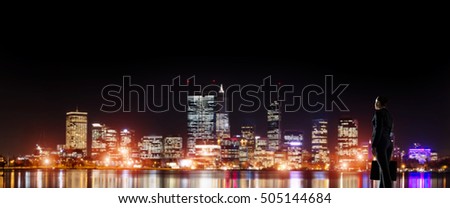 Businesswoman standing with back against night city panoramic view