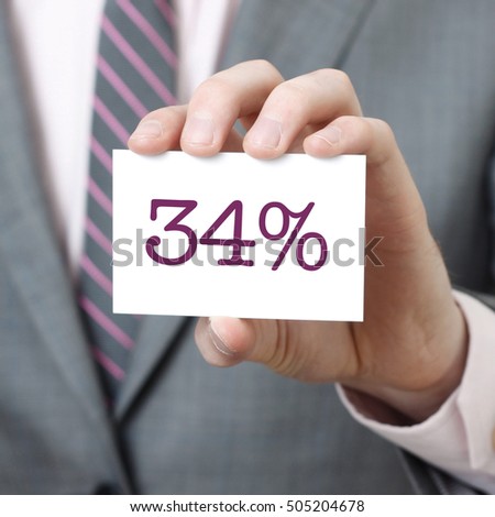34% written on a card held by a businessman