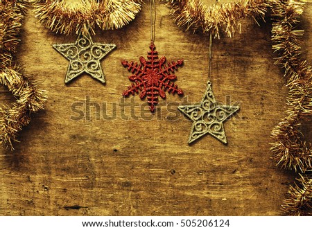 Christmas card with glittering Christmas decorations and stars on a wooden board