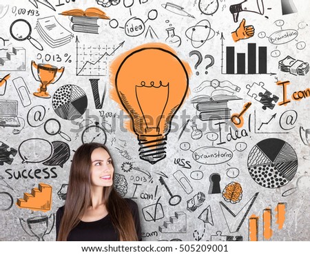 Gorgeous caucasian female on concrete background with creative success sketch and light bulb. Business idea concept