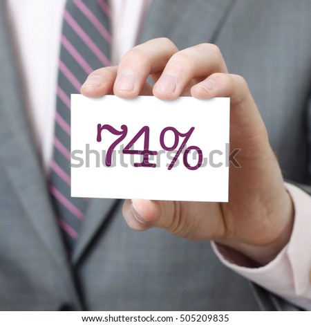 74% written on a card held by a businessman