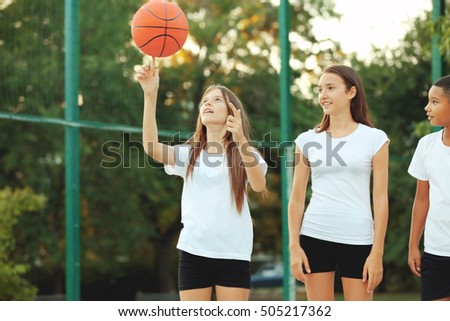 Teenagers playing basketball on school yard