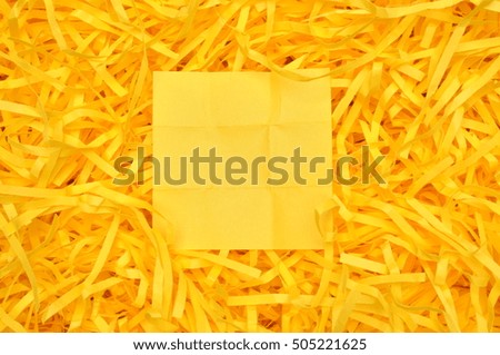Yellow sticky note on shredded paper