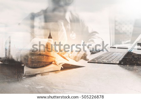 Double exposure,medical doctor writing on notebook and digital tablet docking keyboard with laptop on marble desk,sun flare effect,London city
