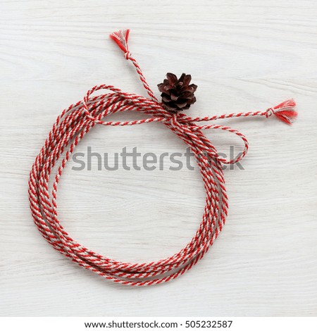 flat layout of the rolled cord into a ring with a bow decorated with cone / holiday background for winter holidays