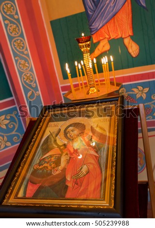 Odessa, Ukraine: A fragment of the interior of the Orthodox Christian Church. The altar, iconostasis, and a beautiful painted icons, frescoes, bas-reliefs in natural light, burning candles, gilding