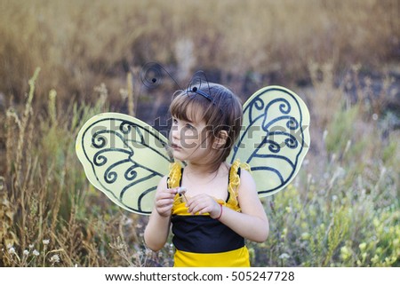 The little girl in a suit of a bee. The girl with wings. The girl dreams and is played.