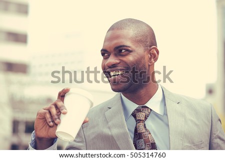 Headshot portrait of young handsome man drinking coffee smiling isolated on outside outdoors city background