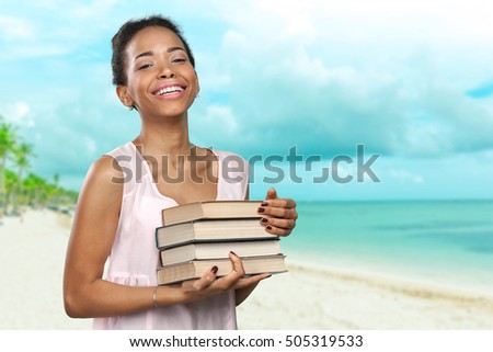 African american woman holding a pile of books
