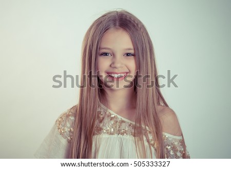 blond little beautiful sunshine girl smiling looking at you camera on green background