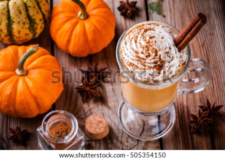 Pumpkin spice latte with whipped cream  on wooden table
