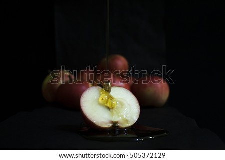 Group of ripe red apples and apple slice with honey close up on black background