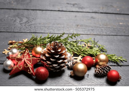 Christmas background. Green Fir tree branches with pine cones, gold snowflakes, ball, stars  on wooden background