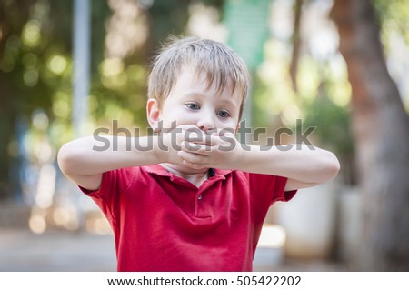 Caucasian little 4-year old boy closing his mouth with hands. Secrecy or stuttering stock image. Speech therapist, speech problems, stammering, stammer, speech impediment, mumble, mumbling. therapy Royalty-Free Stock Photo #505422202