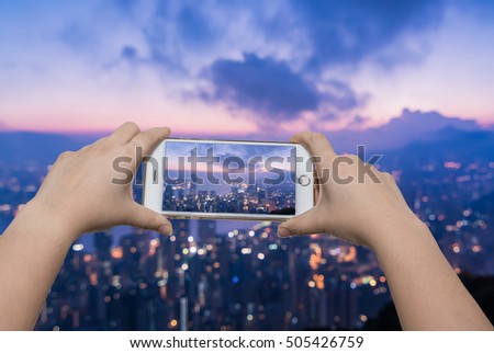 Girl taking pictures on mobile smart phone at Hong Kong from the Victoria peak