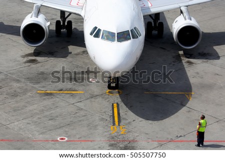 Civil airplane taxiing to the gate. Royalty-Free Stock Photo #505507750