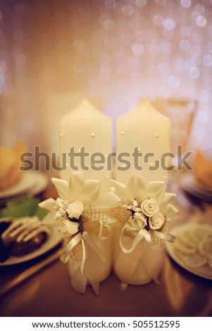 white decorated candles stand on the table