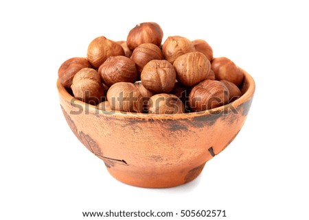 Ceramic bowl of hazelnuts on white