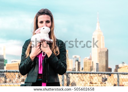 Photo of Girl holding a bunny with Empire State at the Background in Manhattan, New York City